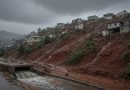 Cidade sob céu carregado com nuvens de chuva e ruas molhadas (imagem ilustrativa)